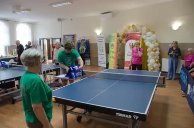 Seniorzy przy stołach i pełna sala w Makowicach podczas turnieju o radość i zdrowie